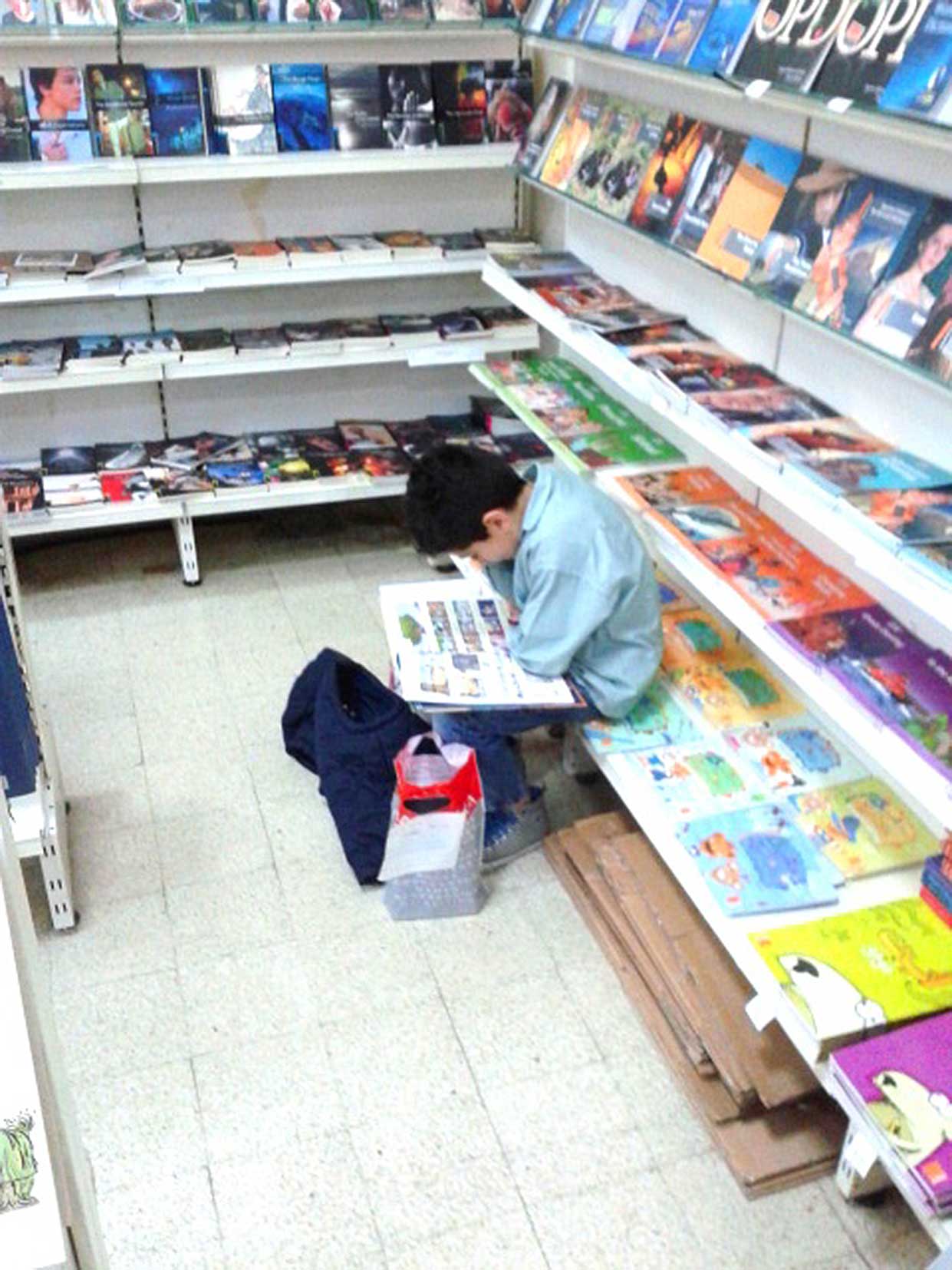Samir Éditeur - Un élève lit un livre sur le stand Samir.